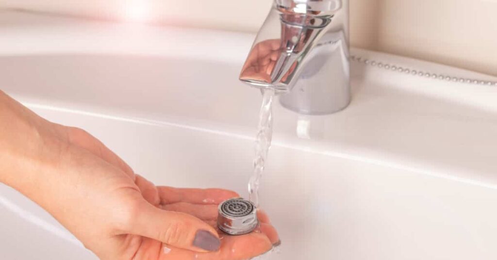 eau qui coule sur les mains d'une personne dans un lavabo