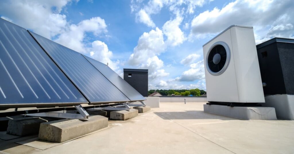 Une unité extérieure de pompe à chaleur à côté de panneaux solaires