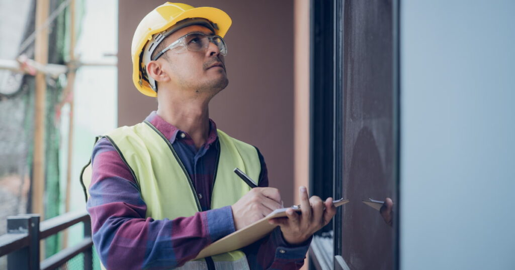 expert en stabilité  avec casque et lunettes de sécurité qui contrôle une maison